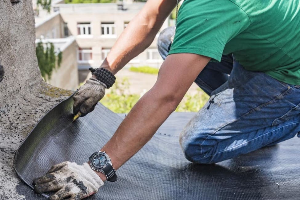 Homem trabalha na impermeabilização do telhado